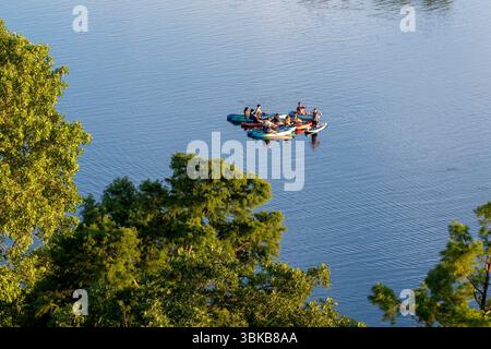 Ein Sommerabend mit Wassersport auf dem Lady Bird Lake in Austin, Texas, wo Kajakfahrer und Wasserliebhaber am 12. Juni 2025 einen Ausflug am späten Abend erleben. Lady Bird Lake, ursprünglich Town Lake und Colorado River genannt, zieht Einheimische und Touristen gleichermaßen an, mit seiner Schönheit und seinem Charme in der Innenstadt von Austin. Stockfoto