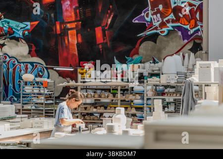 In der Werkstatt Ateliers Arquié in Limoges werden traditionelle Handwerkskunst mit modernen Formen, Farben und Techniken kombiniert. Das Atelier befindet sich in ehemaligen Spinnerei- und Webgebäuden am Ufer der Vienne, an den Wänden sind großformatige Graffiti-Werke regionaler Künstler zu sehen. Avenue Baudin, Limoges, Nouvelle-Aquitaine, Frankreich Stockfoto