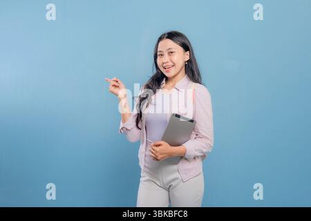 Eine Frau hält einen Laptop und ein Tablet in der Hand. Sie lächelt und sieht in die Kamera Stockfoto