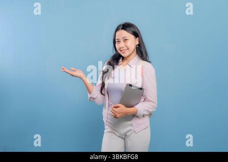 Eine Frau hält eine Tafel und zeigt darauf. Sie lächelt und ist glücklich Stockfoto