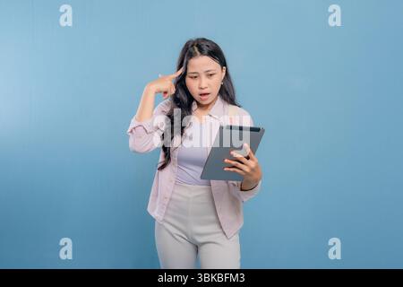 Eine Frau hält eine Tafel und blickt an die Decke. Sie ist tief in Gedanken Stockfoto