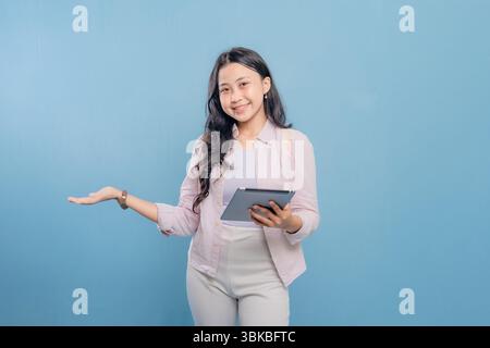 Eine Frau hält eine Tafel und zeigt darauf. Sie lächelt und ist glücklich Stockfoto