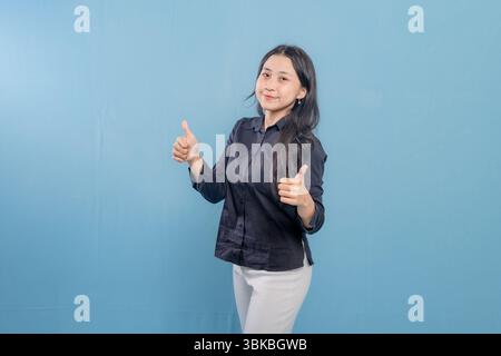 Eine Frau in einem schwarzen Hemd lächelt und hebt ihre Arme in die Luft. Vorstellung von Freude und Feier Stockfoto