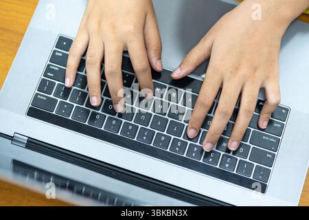 Nahaufnahme der Hände eines Studenten oder Profis, die auf einem Laptop tippen, an einer Aufgabe arbeiten, eine E-Mail schreiben, im Internet surfen oder codin eingeben Stockfoto