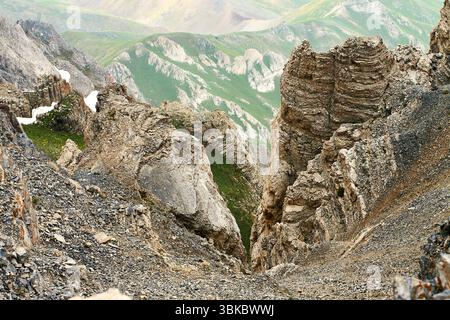 Schneebedeckte Hänge und Wolken, die über das Tal treiben. Blick in die Höhe vom Großgebirge Chimgan in Usbekistan Stockfoto