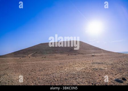 Ein atemberaubender Sonnenaufgang beleuchtet die weite Wüstenlandschaft in der Nähe der Abu Simbel Tempel in Assuan, Ägypten. Das Bild erfasst den Kontrast zwischen dem Gold Stockfoto