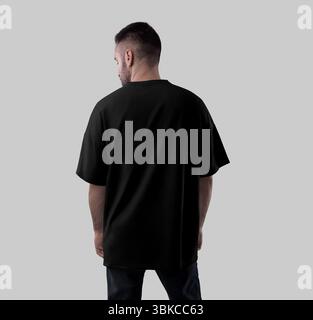 Modell eines schwarzen übergroßen T-Shirts auf Guy, Nahansicht hinten, isoliert auf Hintergrund. Produktfotografie für Werbung. Vorlage eines stylischen Hemdes Stockfoto