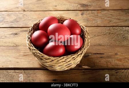 Traditionelle griechische Osterrot gefärbte Eier im Korb auf Holztisch orthodoxes Ostersymbol Stockfoto