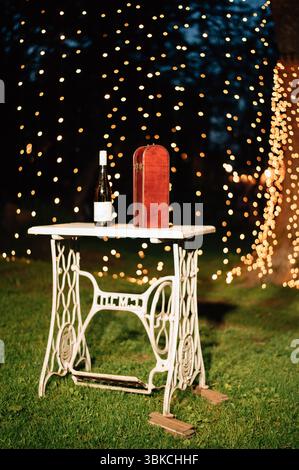 Hochzeitstisch mit einer Flasche Wein und einer Schachtel. Hochwertige Fotos Stockfoto