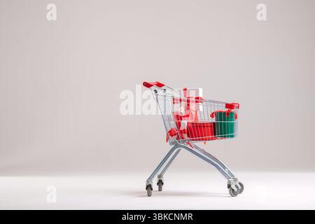 Warenkorb voller Geschenkkartons auf hellem Hintergrund. Stockfoto