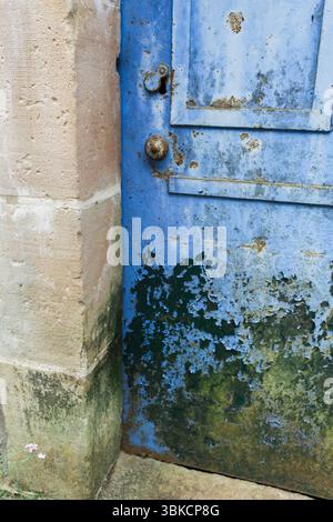 Nahaufnahme einer verwitterten blauen Tür mit Rost und abblätternder Farbe Stockfoto