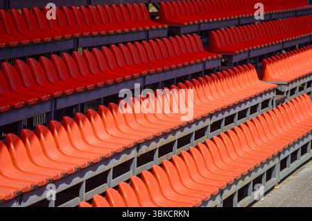 Eine Reihe roter Sitze ist leer. Die Sitze sind in einer Reihe angeordnet, W Stockfoto