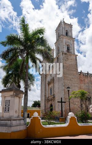 Iglesia de San Servacio Seitenansicht mit Glockenturm und Palmen unter blauem Himmel in Mexiko, Halbinsel Yucatan, Valladolid. Stockfoto