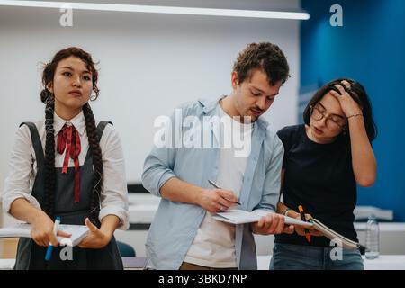 Gruppe verschiedener Schüler, die an einem Unterrichtsprojekt zusammenarbeiten Stockfoto