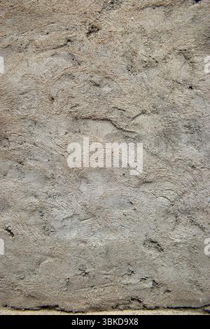 Eine raue strukturierte Zementwandoberfläche mit dunklen Flecken präsentiert Bild Stockfoto