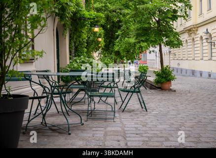 Gemütliche urbane Terrasse eines ruhigen europäischen Cafés mit grünen Stühlen und Tischen Stockfoto