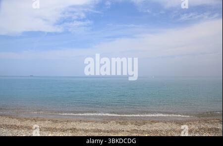 Ein ruhiger Kiesstrand in Gerani, westlich von Platanias auf Kreta, Griechenland. Das weiche türkisfarbene Wasser sorgt für einen perfekten mediterranen Urlaub. Stockfoto