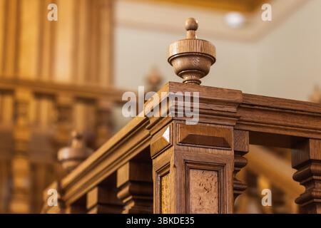 Aufwändig detailliertes Holzgeländer mit klassischem Design, in warmen Tönen hervorgehoben. Ein Beispiel für außergewöhnliche Handwerkskunst, wie sie häufig in hig zu finden ist Stockfoto