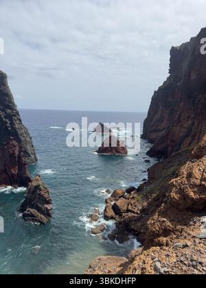 Atemberaubende vertikale Aufnahme der zerklüfteten Küste der Insel Madeira, eines massiven Felsens und der stürzenden Meereswellen. Reisekonzept Stockfoto