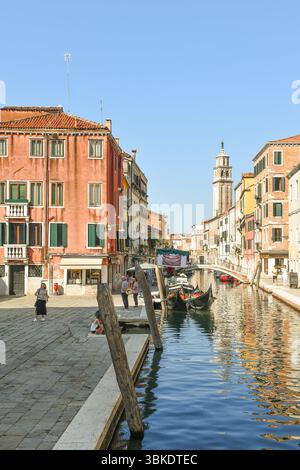 Blick vom Campo San Barnaba mit Gondeln auf den Kanal Rio de San Barnaba, Brücke Ponte dei Pugni und Turm der Kirche Santa Maria dei Carmini, Venedig Stockfoto