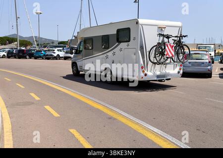 Olbia, Sardinien, Italien - 14. Juni 2025: Ein Wohnmobil mit Fahrradträger fährt im Sommer über den Parkplatz von Olbia auf Sardinien *** ein Wohnmobil mit Fahrradträger fährt im Sommer über den Parkplatz von Olbia auf Sardinien Stockfoto