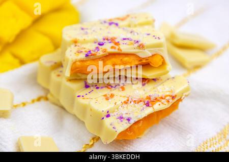 White Mango Dubai Chocolate Bar mit Orangenmango, Passionsfrucht-Aufstrich mit knallenden Süßigkeiten aus nächster Nähe Stockfoto