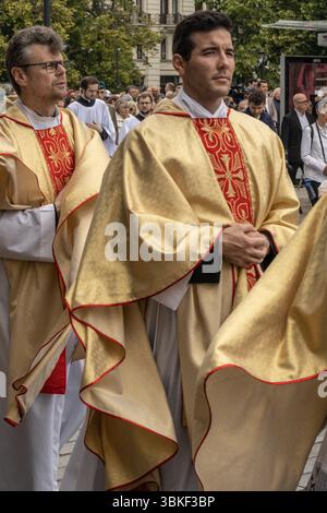 Eine Gruppe katholischer Priester und Pfarrer in goldenen liturgischen Gewändern führt eine Fronleichnamsprozession mit dem Allerheiligsten in Th Stockfoto