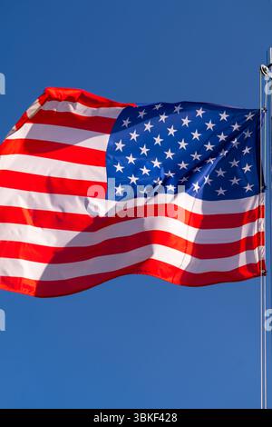 Die US-Flagge auf dem Fahnenmast flattert im Wind. Stockfoto