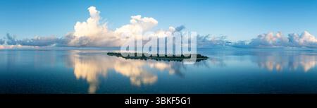 Ein ruhiger Sonnenuntergang erleuchtet eine idyllische Insel im Wakatobi-Nationalpark vor Sulawesi. Dies ist ein beliebtes Ziel für Taucher und Schnorchler. Stockfoto