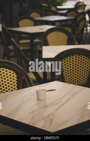 Ein einladendes Café im Freien mit leeren Tischen und Stühlen. Eine ruhige Café-Szene im Freien mit Tischen und Stühlen, perfekt für einen entspannenden Moment. Stockfoto