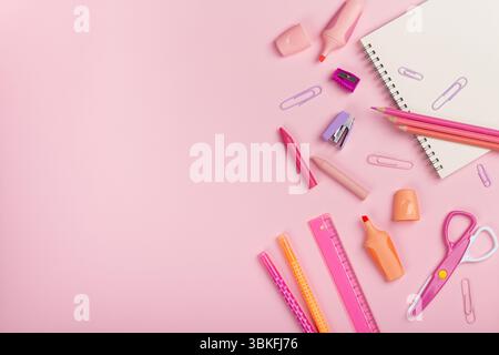 Back-to-School-Konzept. Bleistifte, Spitzer, Schere, Stifte auf rosa Hintergrund mit Kopierraum. Flache Lage, Draufsicht. Stockfoto