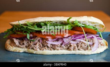 Gourmet-Thunfisch-Sandwich mit frischen Belägen auf handwerklichem Brot Stockfoto