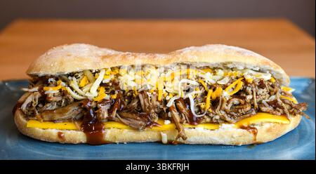 Herzhaftes Pulled Pork Sandwich mit geschmolzenem Käse und BBQ Sauce Stockfoto