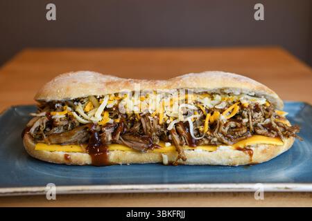 Herzhaftes Pulled Pork Sandwich mit geschmolzenem Käse und BBQ Sauce Stockfoto