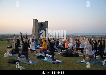 Hadleigh Essex, Großbritannien. Juni 2025. Ein Yoga-Kurs begrüßt The Dawn bei Sonnenaufgängen an der Sommersonnenwende im Hadleigh Castle in Essex, Großbritannien. Die aktuelle Hitzewelle wird voraussichtlich heute (21. Juni 25) ihren Höhepunkt erreichen, wobei die Temperaturen voraussichtlich 34 °C erreichen werden Quelle: MARTIN DALTON/Alamy Live News Stockfoto