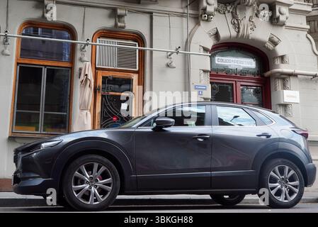 Bukarest, Rumänien – 20. Juni 2025: Nahaufnahme des grauen Autos Mazda CX 30 auf der Straße vor dem Pub Stockfoto