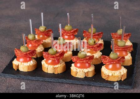 Canapes mit Wurstsalami, Kirschtomaten und Oliven Stockfoto