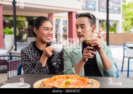 Fröhliche Freunde essen draußen im Café-Restaurant Pizza Stockfoto