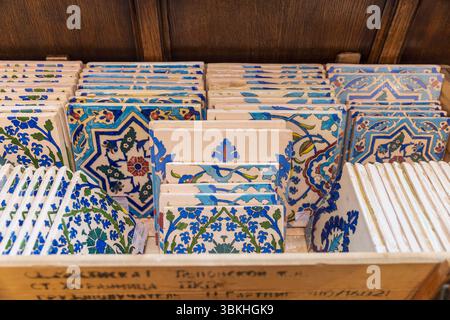 London, Großbritannien, 15. Mai 2025, Liberty Shop. Eine Sammlung von kunstvoll gemusterten Keramikfliesen mit blauen, grünen und roten Motiven ist ordentlich angeordnet Stockfoto