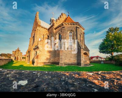 Das Sonnenlicht beleuchtet die elegante Fassade der Kirche im Dorf Butsniv, Ukraine. Altes restauriertes historisches Denkmal Stockfoto