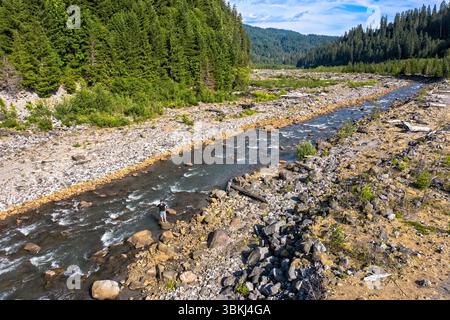 Gifford Pinchot National Forest, Washington, USA - 4. Juli 2019: Ein Mann steht auf Felsen in einem Fluss. Stockfoto