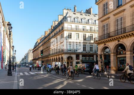 Radfahrer an einem frühen sonnigen Morgen in der Rue de Rivoli, im 1. Arrondissement von Paris. Das tägliche Pariser Leben. Straßenszene. Haussmann-Apartments Stockfoto