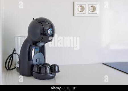 Nahaufnahme der Dolce Gusto Krups Kaffeemaschine und Kapseln auf der modernen weißen Küchentheke. Stockfoto
