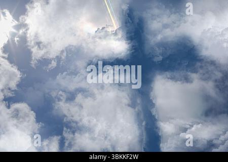 Zentrale dichte Wolken, die kreuzförmig bilden, dominieren flache Himmelskunst mit Objektivfackeln Stockfoto