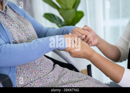 Pfleger helfen asiatische ältere oder ältere alte Dame Frau sitzen auf Rollstuhl zu Hause. Stockfoto