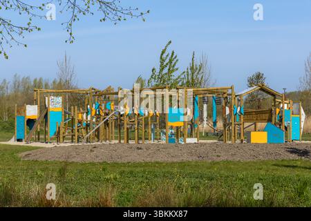 Farbenfroher hölzerner Abenteuerspielplatz in einem Park an einem sonnigen Tag. Perfekt für Outdoor-Aktivitäten und Freizeitaktivitäten für Kinder Stockfoto