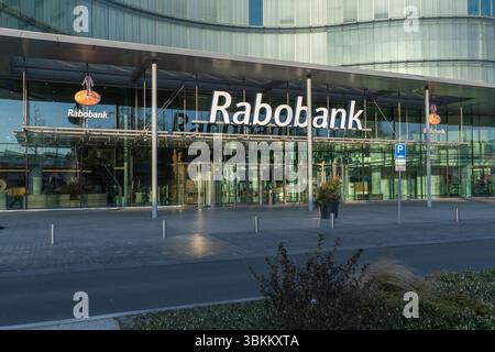 Modernes Bürogebäude des Rabobank-Hauptsitzes aus Glas in den Niederlanden, mit großem Logo und klarem Eingang, das die städtische Architektur widerspiegelt. Utrecht, Net Stockfoto