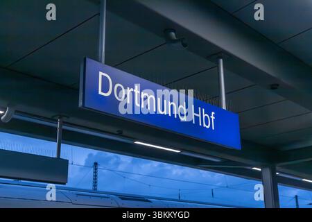 Blaues Schild mit der Aufschrift 'Dortmund Hbf' (Hauptbahnhof) hängt über einem Bahnsteig. Öffentliche Verkehrsmittel. Dortmund, Deutschland. 30. März 2025. Stockfoto