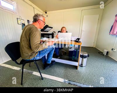 Amt Für Zollhilfe. Fahrer eines Lieferwagens, voll mit Hilfsgütern für die Ukraine am Schalter eines Zollamtes / Angencja Celna, ausfüllen der Dokumente für den ukrainischen Zolldienst. Krowica Holodowska, Polen. Krowica Holodowska Road 866 Woiwodschaft Podkarpackie Polen Copyright: XGuidoxKoppesxPhotox Stockfoto