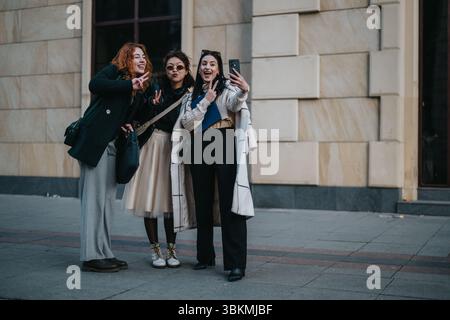Freunde, die ein lustiges Selfie im Freien in der Nähe eines städtischen Gebäudes machen Stockfoto